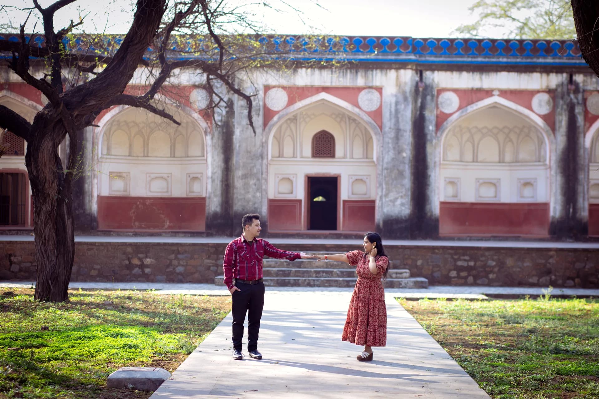 Sun-kissed couple stroll in lush garden setting during evening pre-wedding shoot (Frame #9)