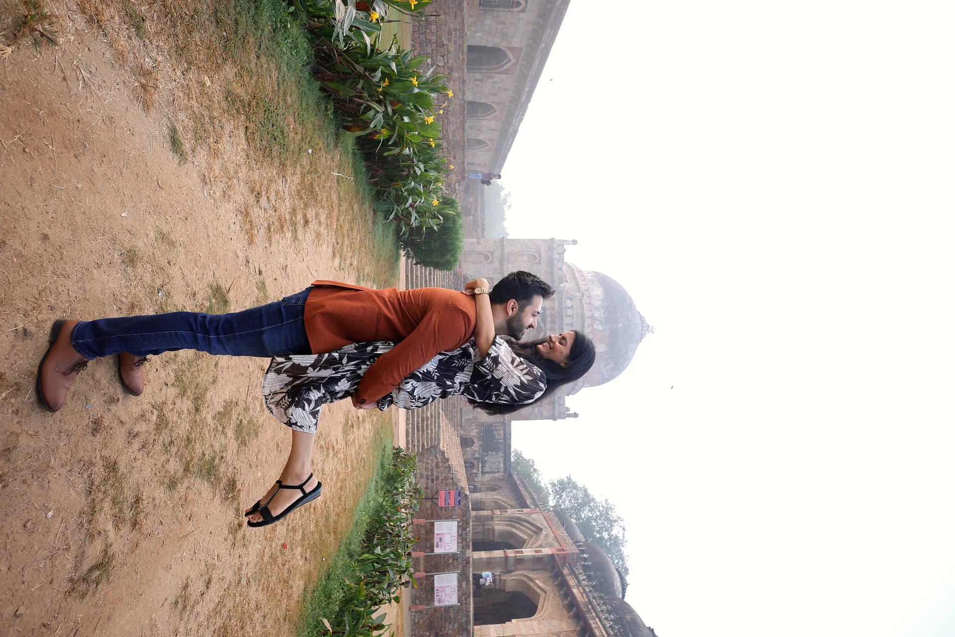 Couple posing against historic architectural archways during outdoor pre-wedding in Delhi (Frame #15)