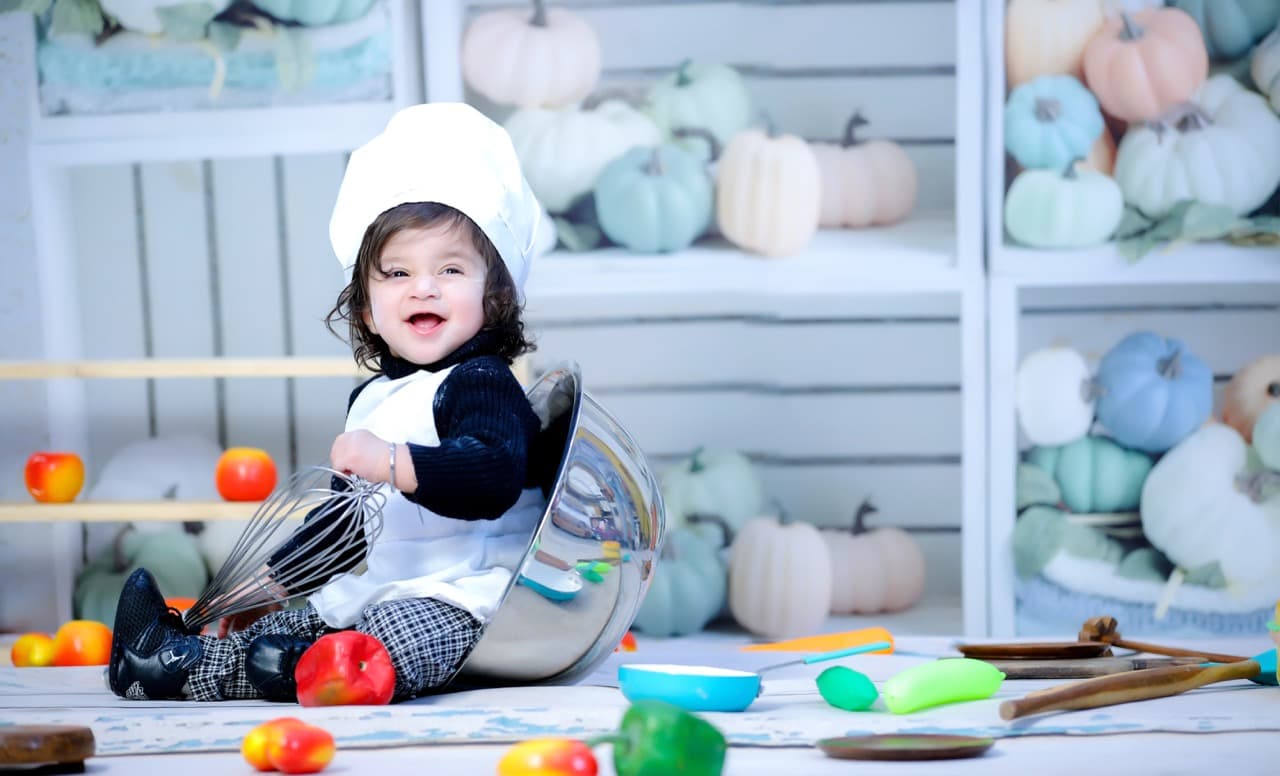 Baby tasting cake icing during first birthday shoot
