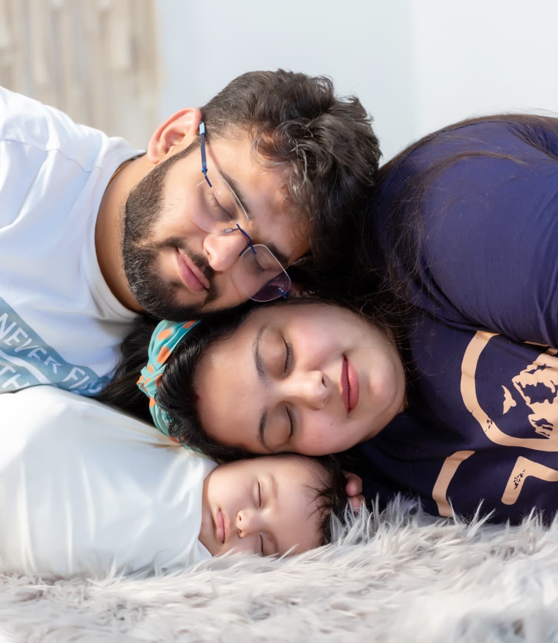 Parents holding baby close in studio family portrait