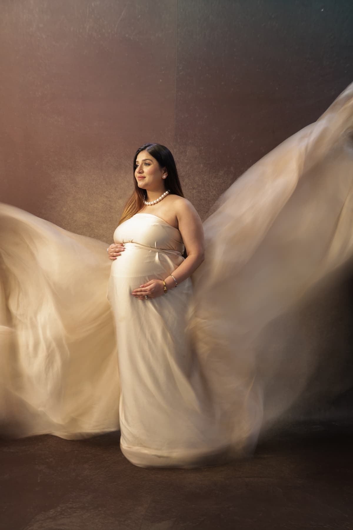 Maternity photoshoot with expectant mother in elegant gown