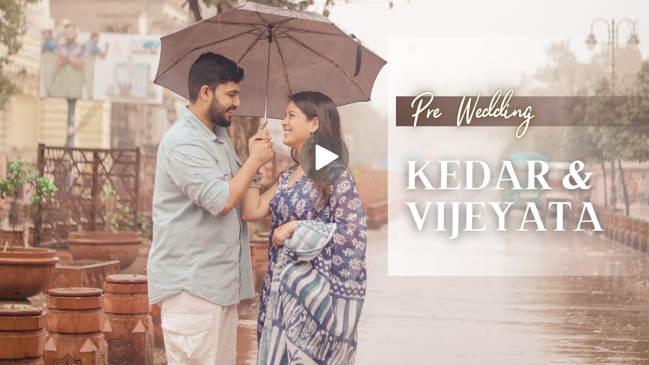 Couple sharing a romantic pre-wedding moment under an umbrella in the rain.